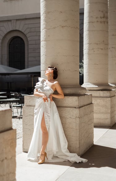 a woman in a white dress standing in front of a column