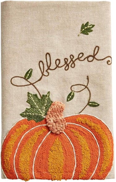 Cotton kitchen towel embroidered with the word blessed and containing an orange pumpkin and leaves.