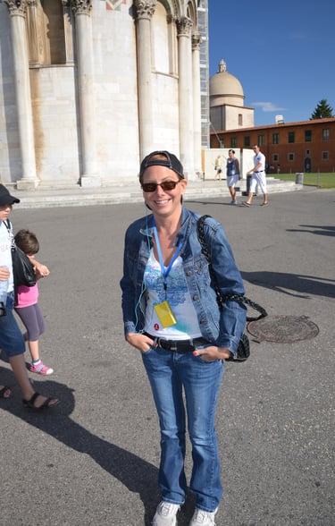 Lady planted on the ground below Leaning Tower of Pisa