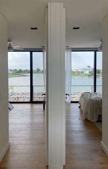 a bedroom with a bed and a large window