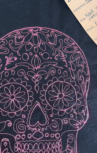 a pink skull on black tshirt lucky threads tag on it