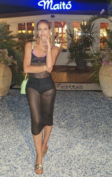 Mary Tornariti in black dress at Maitò restaurant in Forte dei Marmi, Italy.