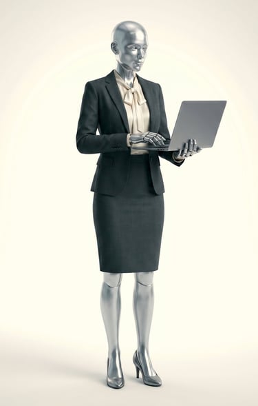 Silver female humanoid robot wearing a professional business suit and typing on a laptop.