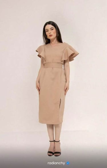a woman in a beige dress with a brown dress