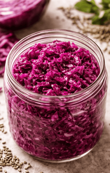 Un frasco de vidrio lleno de chucrut de col morada fermentada, vibrante.