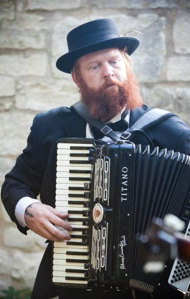 Band member playing accordion during a live performance with Mazel Tov Kocktail Hour