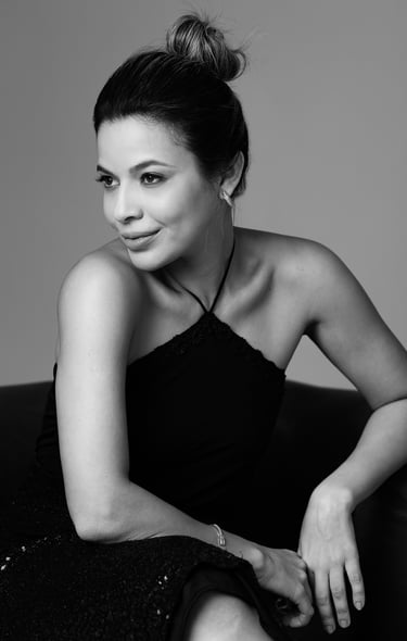 a woman in a black dress sitting on a couch retratos fotografia em estudio São Luís ensaio