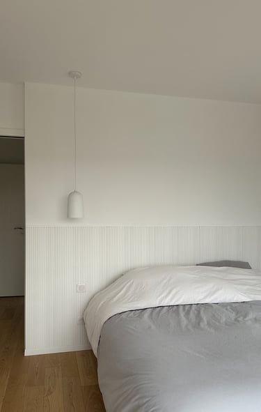  a white bed and a white lamp