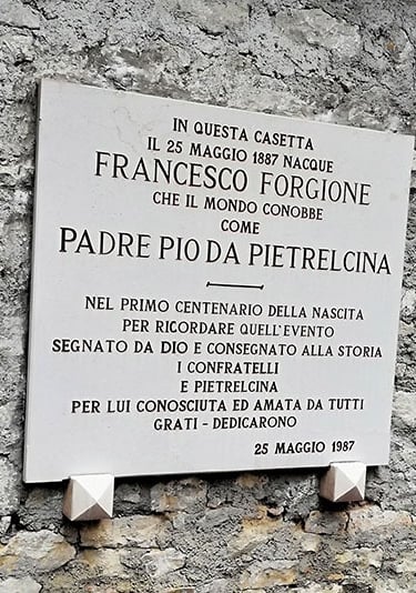 Plaque on wall featuring Padre Pio