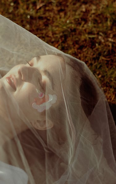 portrait rapproché d'un visage féminin maquillé recouvert d'un voile en tulle transparent