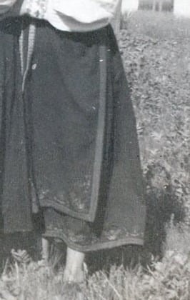 A black and white image of a woman in a bunad