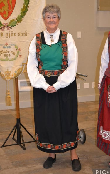 A woman in a Bunad with a green bodice