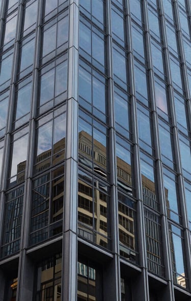 Wide architectural detail of a modern Sydney office tower facade, sharp glass reflections, cool natural daylight.