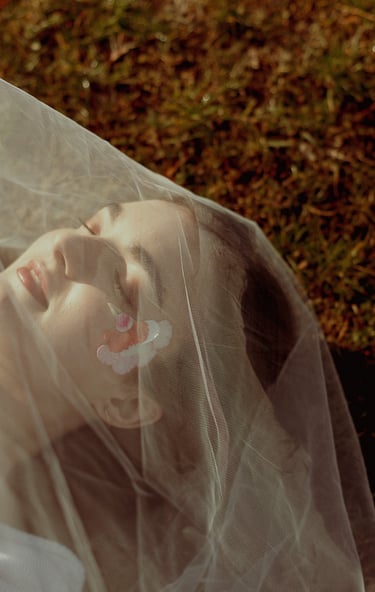 portrait rapproché d'un visage féminin maquillé recouvert d'un voile en tulle transparent