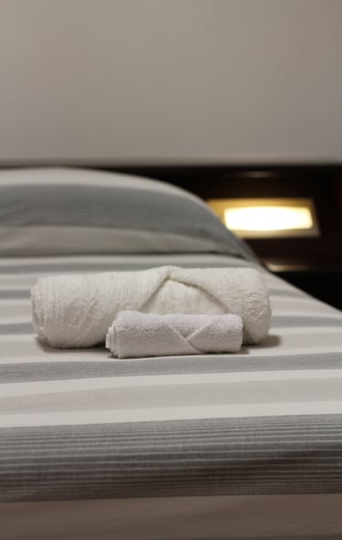 lodgings in sardinia a folded towel on a bed with a folded towel