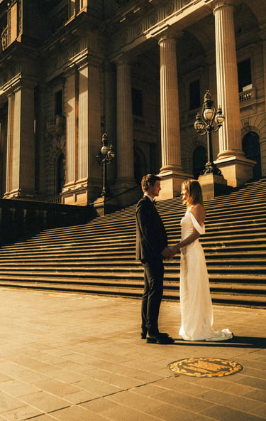 Elegant wedding couple at Parliament House Melbourne captured in cinematic golden light.