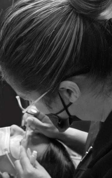 une femme mettant des cils à l'académie Icils avec l'enseignante Irene Molina 
