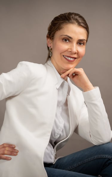 a corporate woman placing her amount on her handin a white shirt and jeans sitting on a chair
