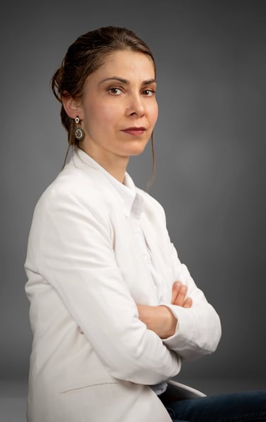 a corporate woman in a white shirt and jeans sitting on a chair