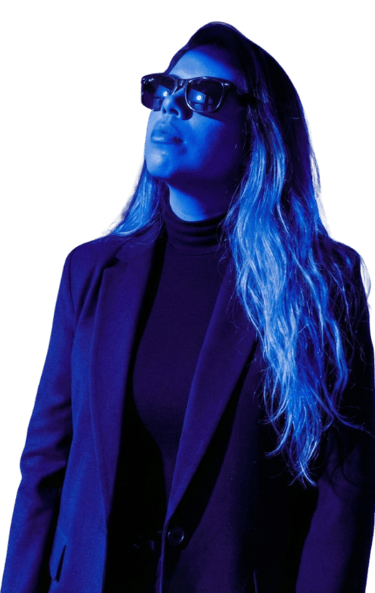 Consultora en marketing digital con blazer y gafas de sol bajo iluminación azul neón.