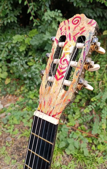 détail de Suun, une peinture sur guitare aux couleurs vives et contrastées - tête de la guitare