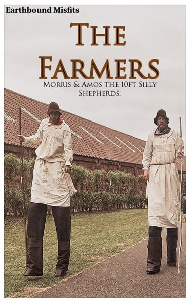 Two Earthbound Misfits performers on 10ft stilts dressed as silly shepherd farmers.
