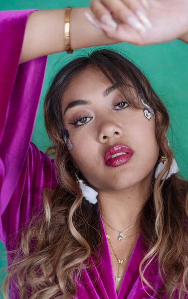 Close-up portrait photo of an Indonesian girl with curly hair and flowers on her face