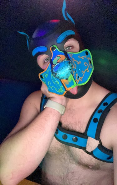 Man posing in a pup mask nad gear.
