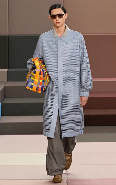 Fendi menswear look in perforated grey coat and checkered tote – Spring Summer 2026.