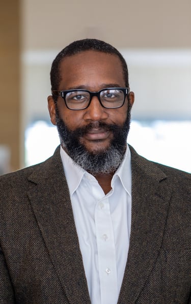 A picture of Dr. Leonard Bright with a beard and glasses on a white background