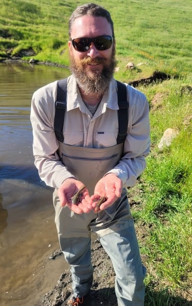 Geoff Cline with two California tiger salamander larvae at a conservation site in Madera County, CA.