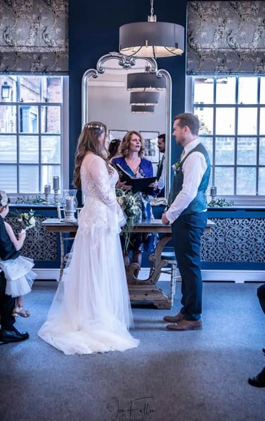 Bride and groom exchanging vows during an indoor wedding ceremony with a marriage celebrant.