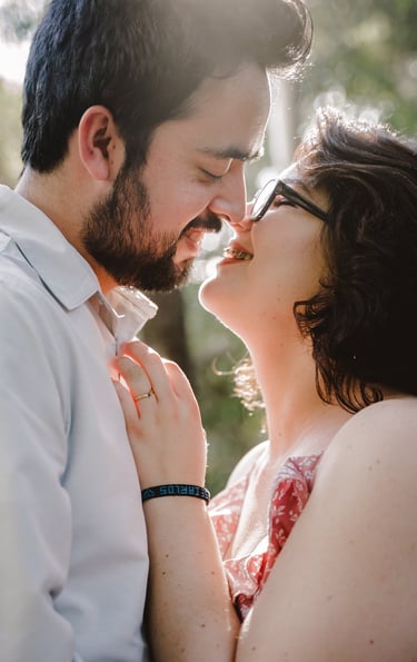 a man and woman kissing in a park