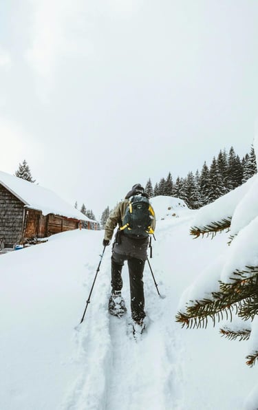 Persona caminant amb raquetes de neu a un refugi