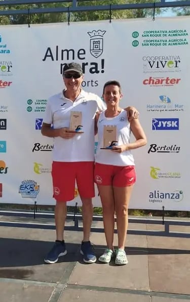 Atletas enseñando el trofeo de primeros en la travesia de almenara