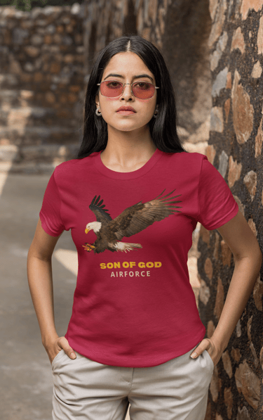 Woman in red t-shirt with eagle and "Son of God Airforce" design, representing faith and strength.