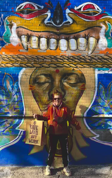 Artist Kate Land in front of vibrant street art