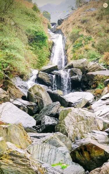 Bhagsunag Waterfall cascading through rocky boulders near McLeod Ganj, Himachal Pradesh.