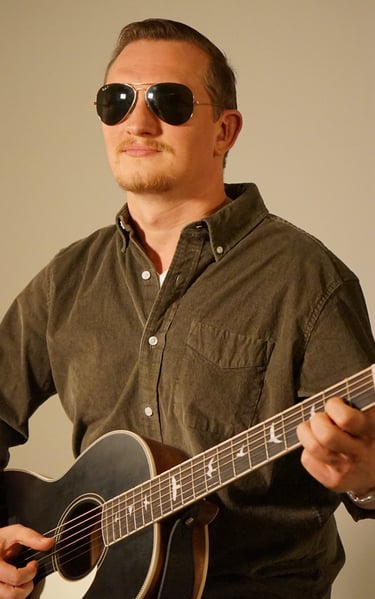 a man with sunglasses holding a guitar