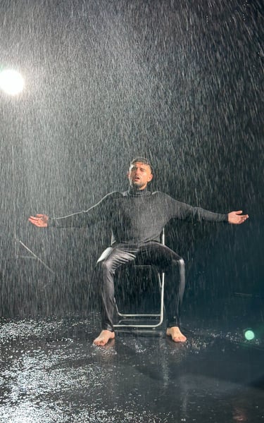 homme sur fond noir avec de la pluie artificielle