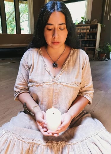Mujer sentada sosteniendo una vela encendida
