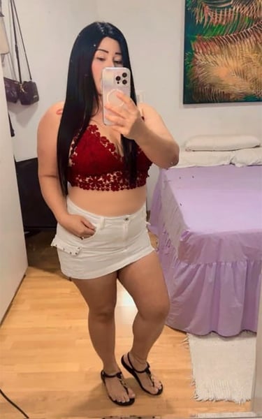 Viky con falda blanca y top rojo, look casual sexy frente al espejo