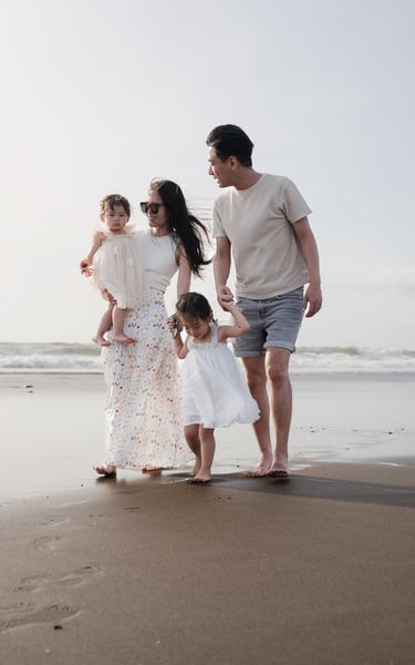 Family enjoying a relaxed walk along Petitenget Beach Seminyak Bali during a natural family photo session