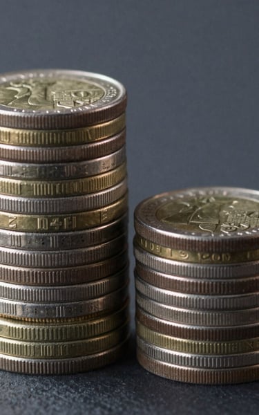 stacked round gold-colored coins on white surface