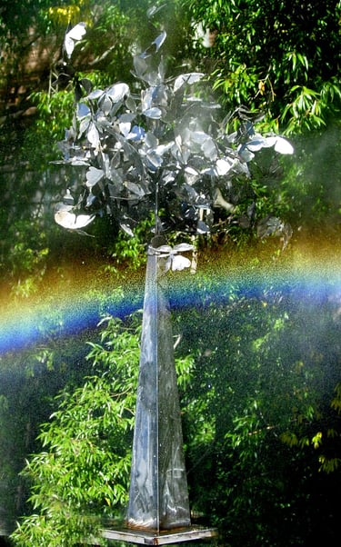 sculpture of a chrome pyramid with a ball of butterflies on top