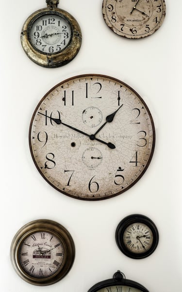 plusieurs vieilles horloges accrochées sur un mur et donnant des heures différenes. Unsplash.