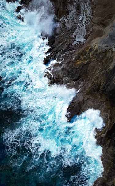 a person standing on a cliff side with a surfboard
