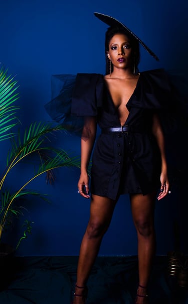 Une femme en robe haute couture noire et chapeau Anais Ricard 