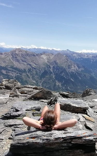 a woman laying on a rock in the mountains