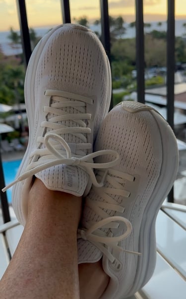 Brooks Ghost Max 2 running and walking sneakers in bright white, worn on feet with a Hawaii sunset i